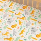 Close-up of vibrant jungle-themed baby cot sheet with lions, elephants, and tropical leaves