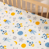 Close-up of galaxy-themed baby bedding with planets, shooting stars, and rocket ships in vibrant colors