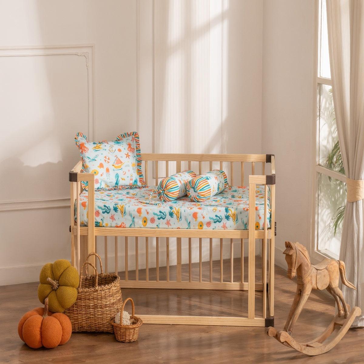 Under the Sea baby cot sheet set with matching pillowcase and bolster covers featuring ocean-themed prints like fish, and plants