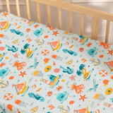 Close-up of underwater-themed cot sheet showing colorful fish, coral reefs, and marine patterns.