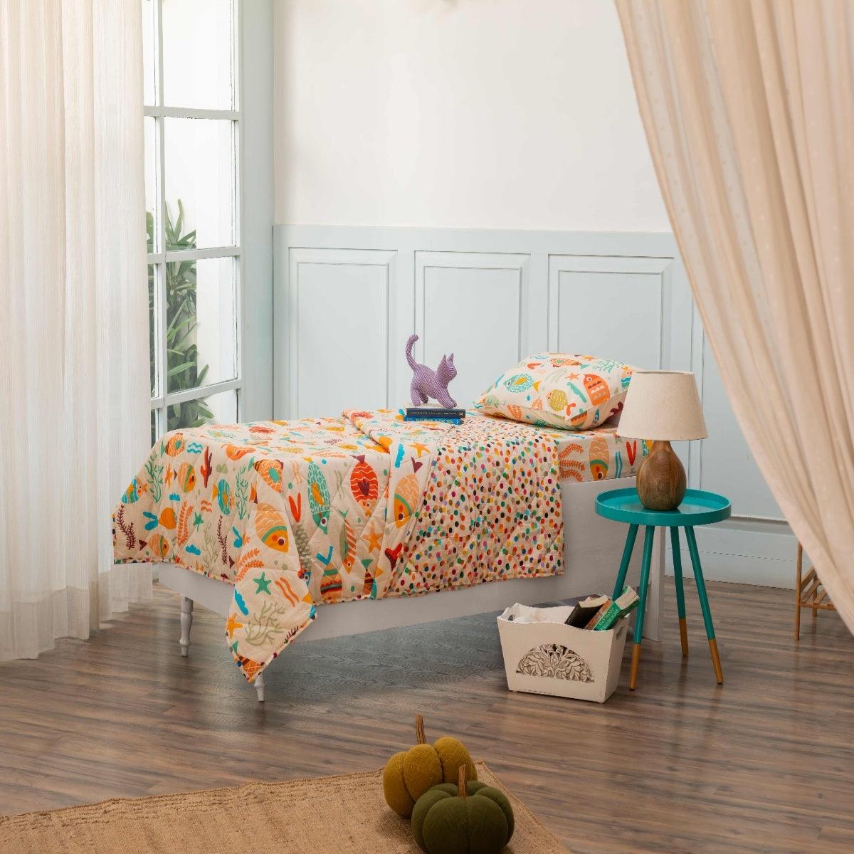 Kids bedding set with Under the Sea print styled in a cozy bedroom, featuring comforter, bedsheet, and pillow cover in marine-themed designs.