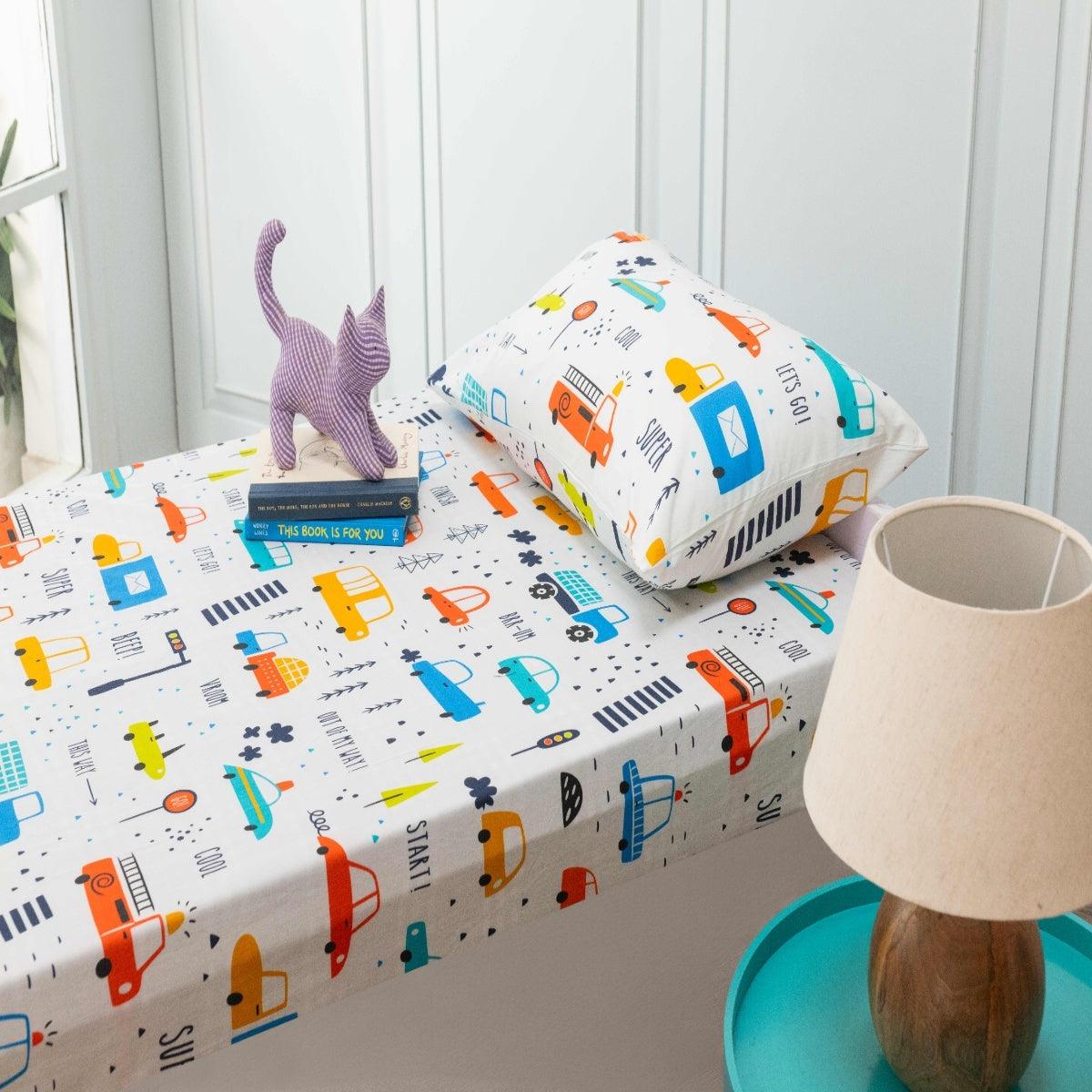 Kids bedsheet and pillow cover set featuring colorful transportation print with cars, buses, and traffic signs on a soft cotton fabric.
