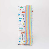 Reversible quilted kids blanket featuring transportation-themed prints with cars, buses, and road signs.